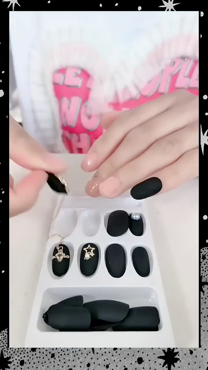 Stunning Black Matte Nails Adorned with Elegant Silver Star and Heart Jewelry Accents – Perfect for a Bold and Fashion-Forward Look