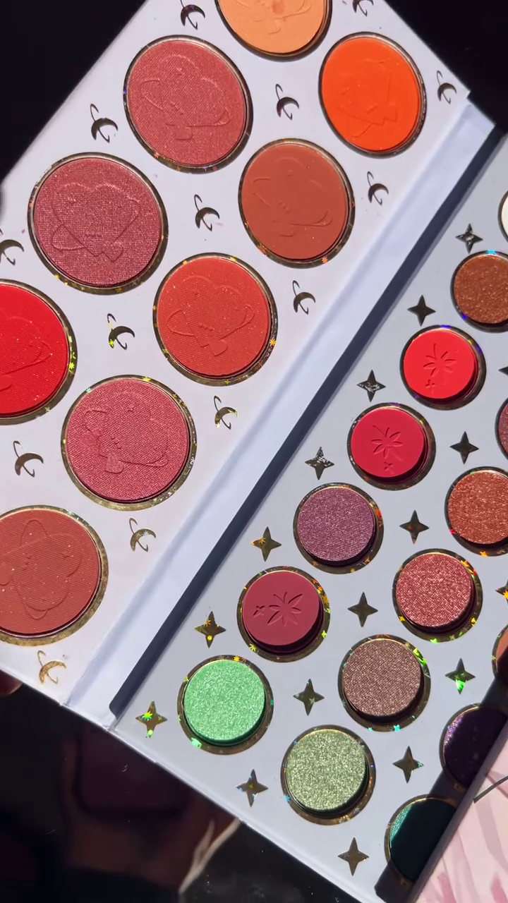 Close-Up of a Stunning Colorful Eyeshadow Palette Featuring Rich, Vibrant Shades of Red, Green, Purple, and Gold, with a Touch of Holographic Detailing for a Glamorous Look