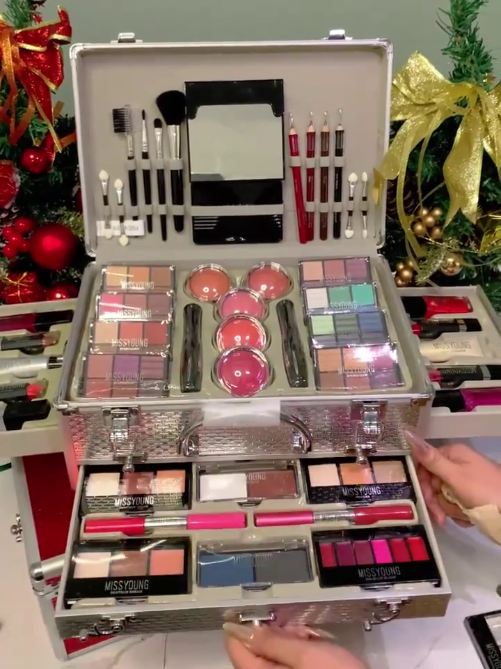 Vibrant Makeup Collection by Miss Young, Featuring a Variety of Lipsticks, Lip Glosses, Eyeshadows, Blushes, Brushes, and Pencils, Organized in a Stylish Red Makeup Case – Perfect for Holiday Glam and Gift Giving.