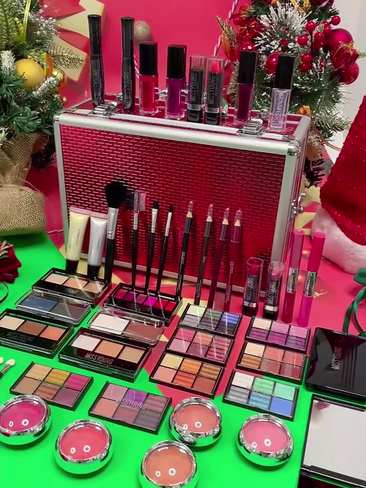 Vibrant Makeup Collection by Miss Young, Featuring a Variety of Lipsticks, Lip Glosses, Eyeshadows, Blushes, Brushes, and Pencils, Organized in a Stylish Red Makeup Case – Perfect for Holiday Glam and Gift Giving.