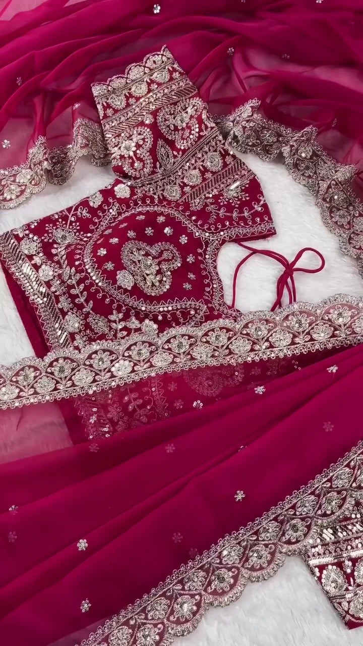 Deep Rani Pink Georgette Saree Ensemble Featuring a Heavily Embellished Blouse and Matching Dupatta Border Lavishly Adorned with Intricate Silver Zari Embroidery and Sparkling Stone Work