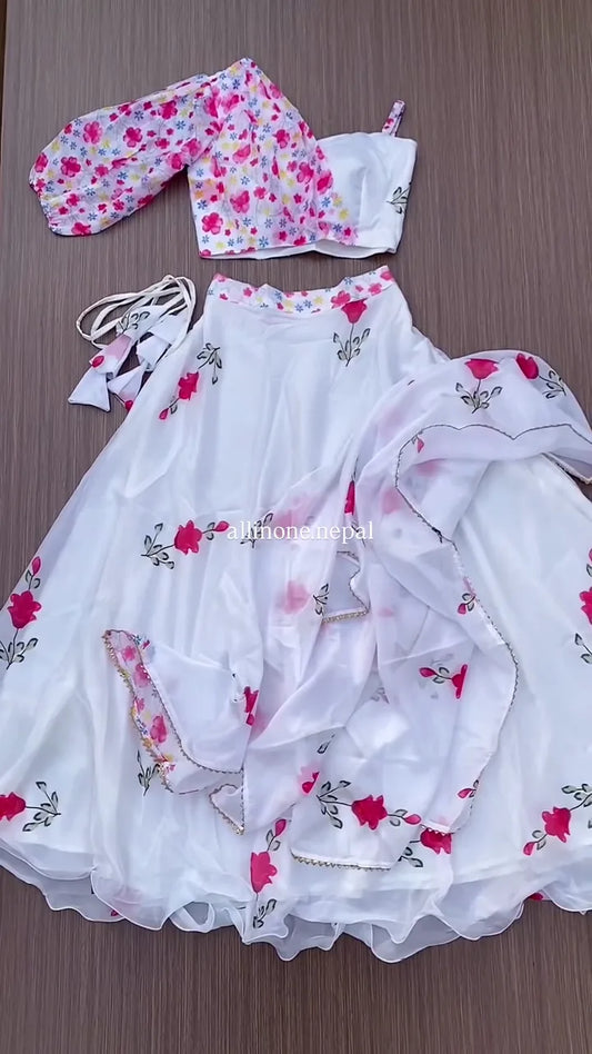 White Floral Lehenga Choli Set with Vibrant Pink Rose Print, Featuring a Flowing Skirt, a Contrast Pink Floral Print Crop Top with Voluminous Sleeves, and a Coordinating Sheer Dupatta