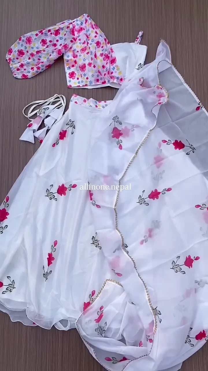 White Floral Lehenga Choli Set with Vibrant Pink Rose Print, Featuring a Flowing Skirt, a Contrast Pink Floral Print Crop Top with Voluminous Sleeves, and a Coordinating Sheer Dupatta