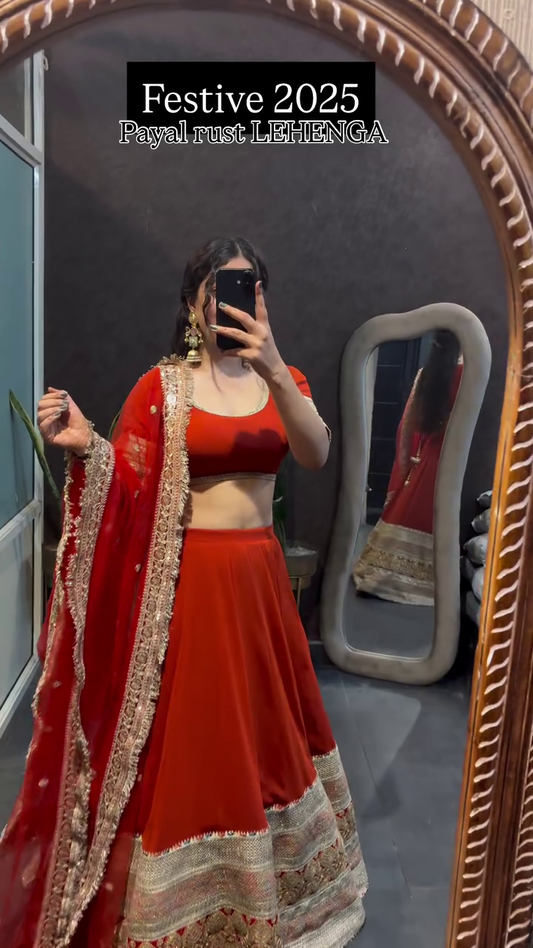Festive Rust Payal Lehenga with Red Chiffon Dupatta and Intricate Golden Embroidery for a Stunning Traditional Look