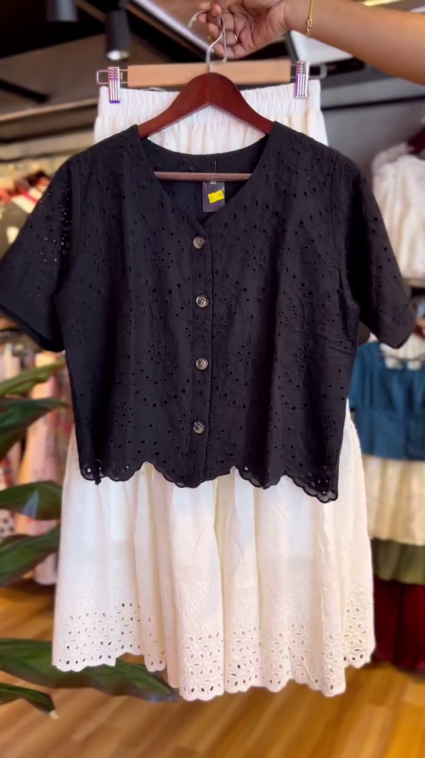 Two-Piece Cotton Co-Ord Set Featuring a Black Short Sleeve Button-Up Broderie Anglaise Top and a White High-Waisted Tiered Midi Skirt with Eyelet Embroidery Detailing – Perfect for Casual Summer Days or Chic Outings